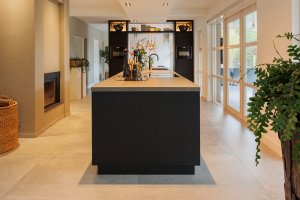 Mat zwart keukeneiland met gebeitste apparatuurwand & haard meubel